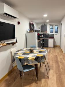 - une cuisine et une salle à manger avec une table et des chaises dans l'établissement Les Gîtes de la Bergerie - Boule de Neige, à Meximieux