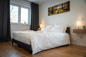 a bedroom with a large bed with white sheets at ApartHome - LUXUS PUR auf 91m2 Klima in Eching