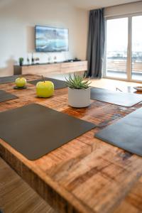 drewniany stół z matami na górze w obiekcie ApartHome - LUXUS PUR auf 91m2 Klima w mieście Eching