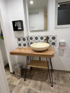 a bathroom with a bowl sink on a wooden counter at Les Gîtes de la Bergerie - Boule de Neige in Meximieux +17 photos