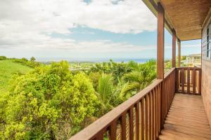 uma varanda de uma casa com vista para o oceano em Mélo Appart avec sa terrasse spacieuse et vue entre Mer & montagne em Sainte-Marie