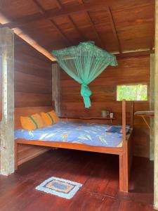 a bed in a wooden cabin with a net at Coco Cabins by Thush in Bentota