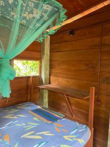 Coco Cabins by Thush في بينتوتا: غرفة نوم بسرير ونافذة في غرفة