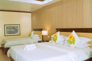 2 łóżka w pokoju hotelowym z białą pościelą w obiekcie Boracay Peninsula w mieście Boracay