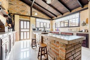 a large kitchen with a brick wall and two stools at Quinta María Alfonsina in Ibarra