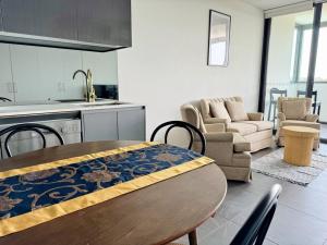 uma cozinha e sala de estar com uma mesa de madeira num quarto em Modern 2Brs@ close2 Olympic park em Sidney