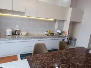 a kitchen with white cabinets and a marble counter top at NM Homestay in Kampot