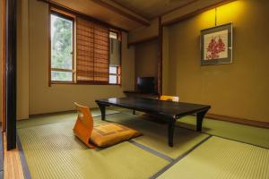 uma sala de estar com uma mesa e uma cadeira em Takamiya Hotel Hammond em Zao Onsen