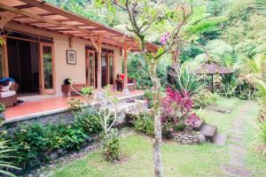 a house with a porch and a garden at Carik Tangis Boutique Homestay in Jatiluwih
