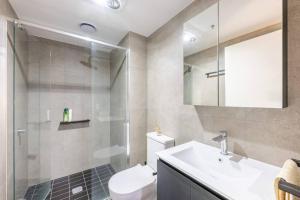 a bathroom with a sink and a toilet and a shower at Convenient Located 2 bedroom apartment in Braddon in Canberra