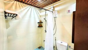 a bathroom with a shower curtain and a toilet at Bougan Villea Retreat in Bodufolhudhoo