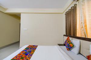 a bedroom with a bed with a colorful pillow at FabHotel New Annapurna Plaza in Pātipukur