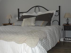a bedroom with a large bed with white sheets and pillows at Jardin de Canaan in Saint-Julien-de-Chédon