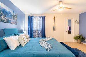 Una cama azul con almohadas en el dormitorio en Escape the City w/King Bed, Arcade Games & Firepit, en Norcross