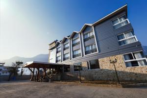 a large building with awning in front of it at Kaizen X Voyage Resort And Spa, Manali in Manāli