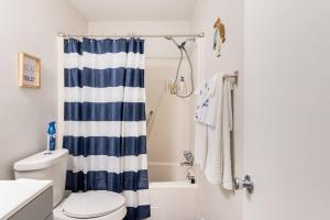 Un baño con una cortina de ducha azul y blanca. en Escape the City w/King Bed, Arcade Games & Firepit, en Norcross 58 fotos más