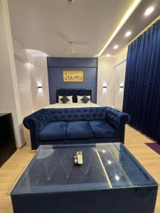 a bedroom with a blue couch and a bed at The Royal Residency Suites,Lucknow Gomti Nagar in Lucknow