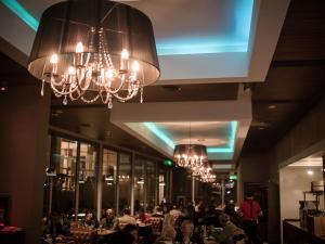 a dining room with people sitting at tables and chandeliers at Hotel Del Bono Park in San Juan +78 photos