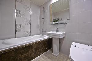 ein Badezimmer mit einem Waschbecken, einer Badewanne und einem WC in der Unterkunft Busan Beach Hotel Busan Songdo in Busan