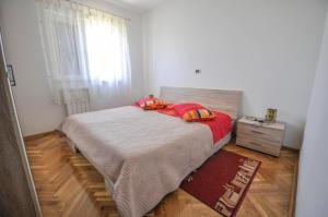 Un dormitorio con una cama con sábanas rojas y una ventana en Große Ferienwohnung in Dajla mit Garten und Terrasse, en Dajla