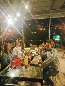 a group of people sitting at a table with food at TIGOLD Homestay DALAT INN in Da Lat