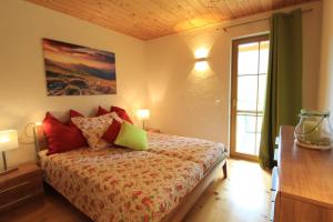 een slaapkamer met een bed met rode kussens en een raam bij Wohnung in Bach mit Terrasse und Garten in Bad Kleinkirchheim