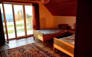 - une chambre avec 2 lits et une grande fenêtre dans l'établissement Ferienhaus See in Sicht, à Wolfhalden 