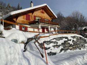eine Blockhütte im Schnee mit einer Steinwand in der Unterkunft Cœur du Valais, à 4 mn du centre de Crans-Montana in Crans-Montana