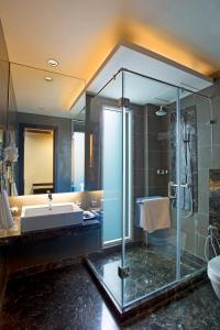 Jasmine Boutique Hotel Jasola في نيودلهي: حمام مع حوض ومغسلة ودش