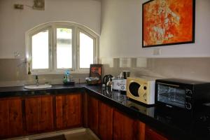uma cozinha com um balcão e um micro-ondas em Silvawood Banglow em Rangala