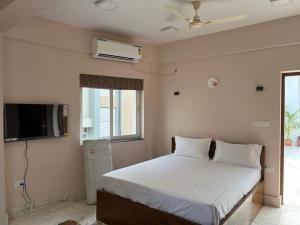 a bedroom with a bed and a flat screen tv at The Broome Kolkata in Kolkata