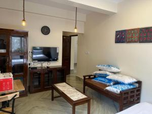 a living room with a couch and a tv at The Broome Kolkata in Kolkata