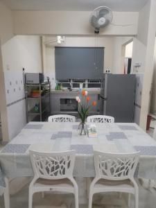 cocina con mesa, 2 sillas y mesa en Sweet Homestay, en Port Dickson