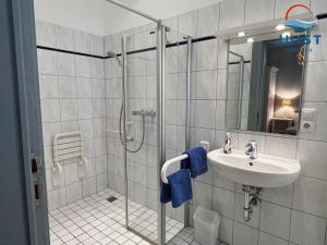 y baño con lavabo y ducha. en Pension Marie Luise 251 - Zimmer Herzmuschel en Juist