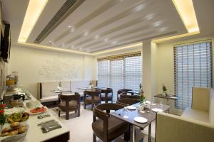 a restaurant with tables and chairs in a room at Jasmine Boutique Hotel Jasola in New Delhi