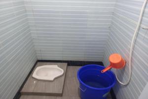 - une petite salle de bains avec des toilettes et un seau dans l'établissement SPOT ON 93557 Juan Kostel 2, à Purwokerto