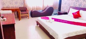 una habitación de hotel con 2 camas y una silla en Phát Thịnh Hotel, en Ho Chi Minh