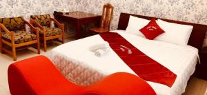 Schlafzimmer mit einem Bett mit einer roten und weißen Decke in der Unterkunft Phát Thịnh Hotel in Ho-Chi-Minh-Stadt