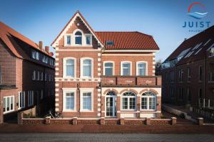 un grande edificio in mattoni con tetto rosso di Pension Marie Luise 252 - Zimmer Venusmuschel a Juist