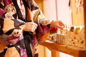 Una mujer con un vestido buscando una caja de sushi en 別所温泉 七草の湯, en Ueda