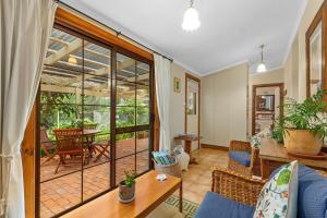 een woonkamer met een tafel en stoelen bij Miriams Cottage in Tanunda