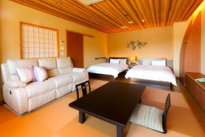 a living room with a couch and two beds at 別所温泉 七草の湯 in Ueda