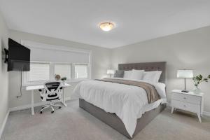 a bedroom with a bed and a desk and a computer at Luxurious and Beautiful, Ottawa in Ottawa