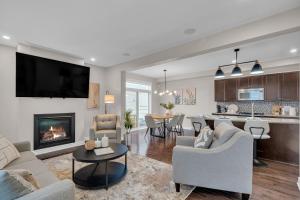 a living room with a fireplace and a kitchen at Luxurious and Beautiful House in Ottawa
