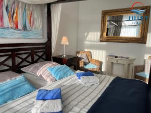 1 dormitorio con cama con almohadas azules y espejo en Pension Marie Luise 255 - Zimmer Kammmuschel en Juist