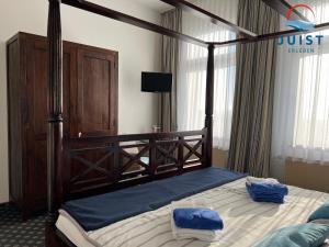 a bedroom with a large bed with a wooden frame at Pension Marie Luise 255 - Zimmer Kammmuschel in Juist +5 photos