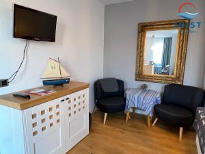 a living room with two chairs and a mirror at Pension Marie Luise 257 - Kombi-Zimmer Auster in Juist