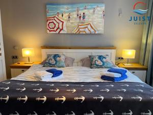 ein Schlafzimmer mit einem Bett mit zwei Lampen und einem Gemälde in der Unterkunft Pension Marie Luise 257 - Kombi-Zimmer Auster in Juist