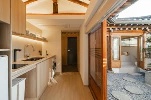 a kitchen with wooden cabinets and a ceiling with a window at Luxury hanok with private bathtub - SN18 in Seoul