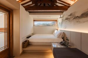 a small bedroom with a bed and a window at Luxury hanok with private bathtub - SN18 in Seoul